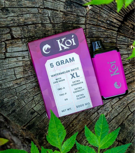 Koi vape with packaging on a tree stump